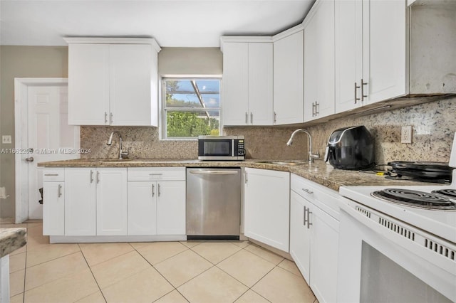 kitchen featuring light stone counters, sink, white cabinetry, stainless steel appliances, and backsplash