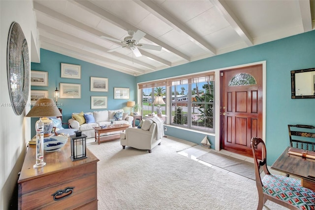 carpeted living room featuring ceiling fan and lofted ceiling with beams