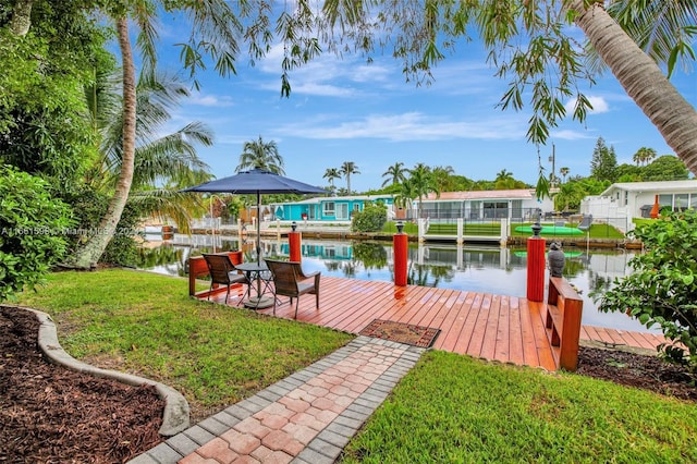 view of dock featuring a lawn and a water view