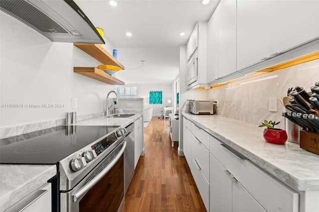 kitchen featuring white cabinetry, sink, wood-type flooring, and appliances with stainless steel finishes