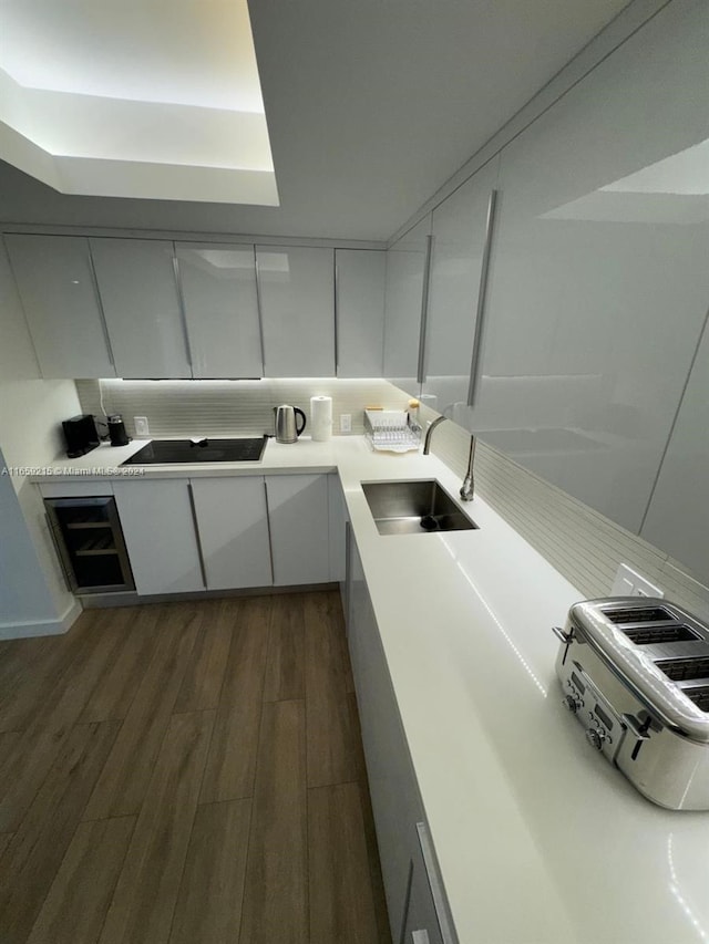 kitchen featuring black electric stovetop, white cabinetry, dark hardwood / wood-style floors, and sink