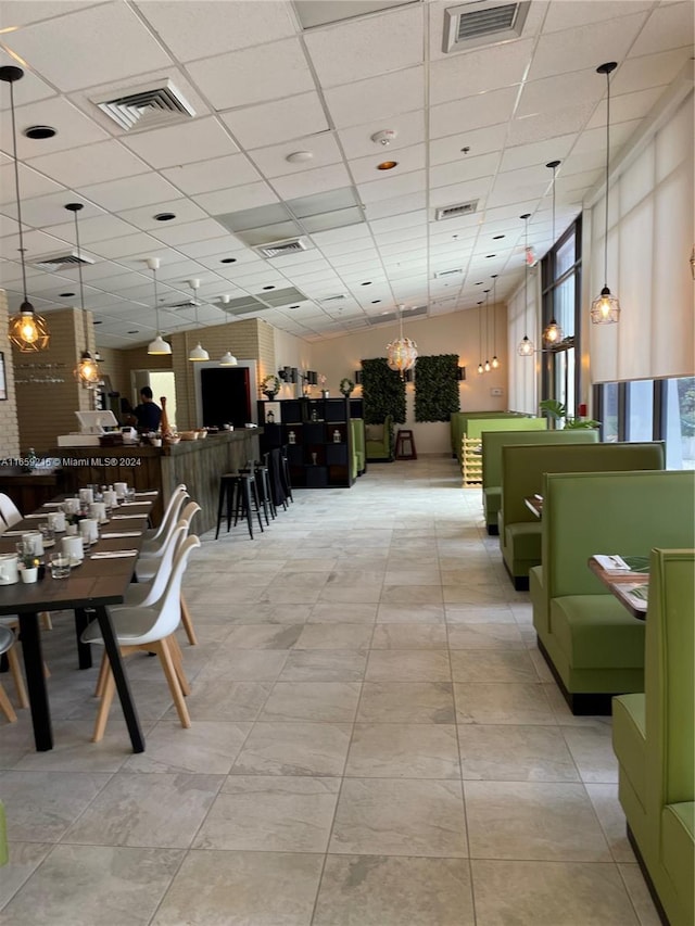 interior space with a drop ceiling and light tile patterned flooring