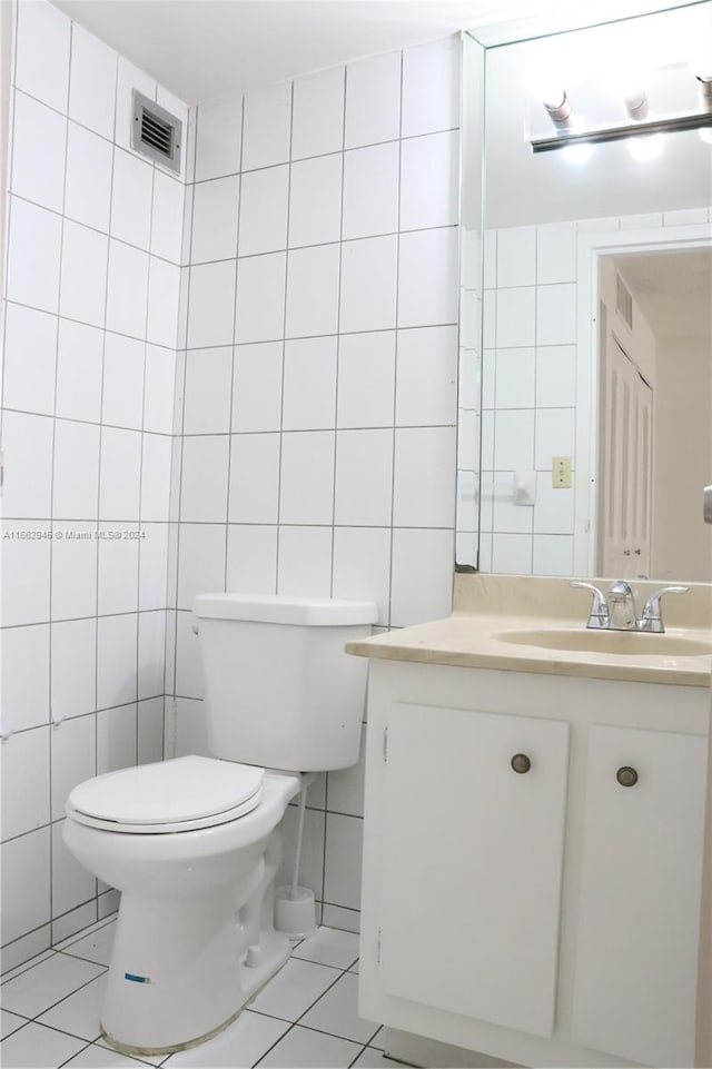 bathroom featuring tile walls, tile patterned flooring, vanity, and toilet