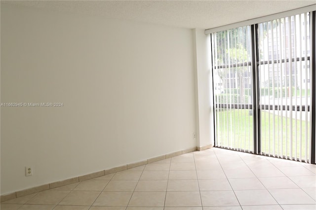 spare room featuring a textured ceiling and light tile patterned floors