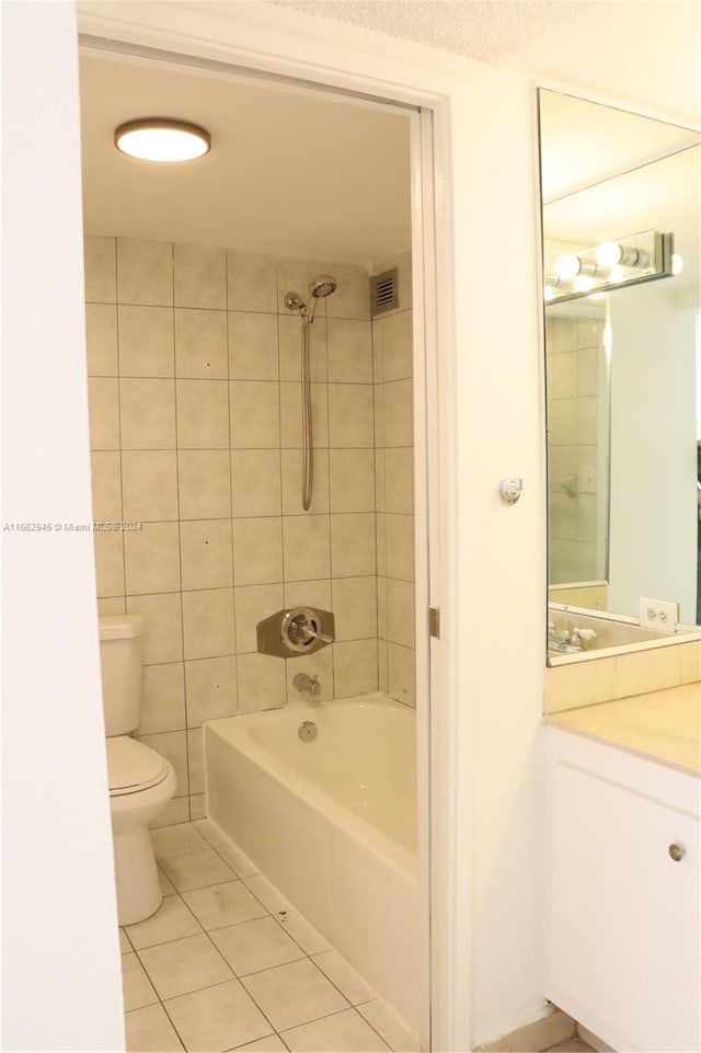 full bathroom with tile walls, vanity, tile patterned flooring, toilet, and tiled shower / bath