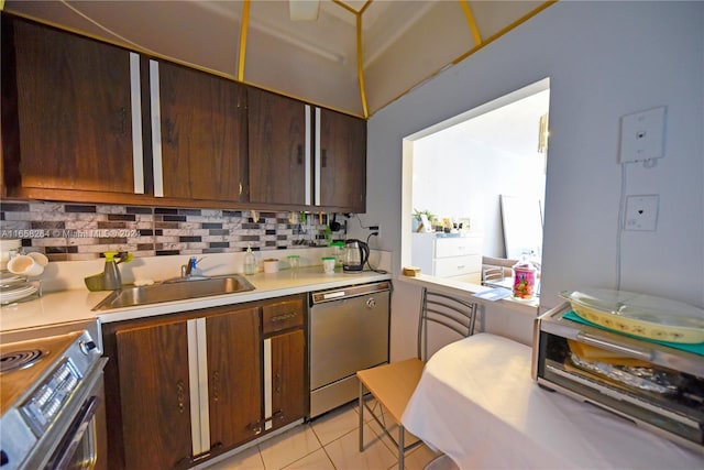 kitchen featuring dark brown cabinets, light tile patterned flooring, tasteful backsplash, sink, and appliances with stainless steel finishes