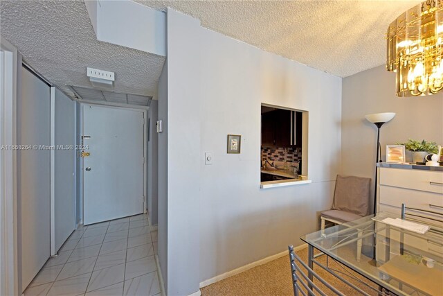 200 172nd St Unit 306, Sunny Isles Beach, FL 33160 - corridor featuring a textured ceiling, a chandelier, and baseboards