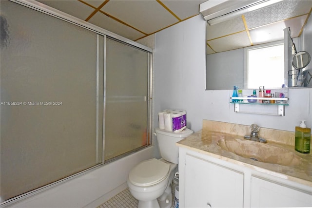 full bathroom featuring tile patterned floors, combined bath / shower with glass door, vanity, and toilet