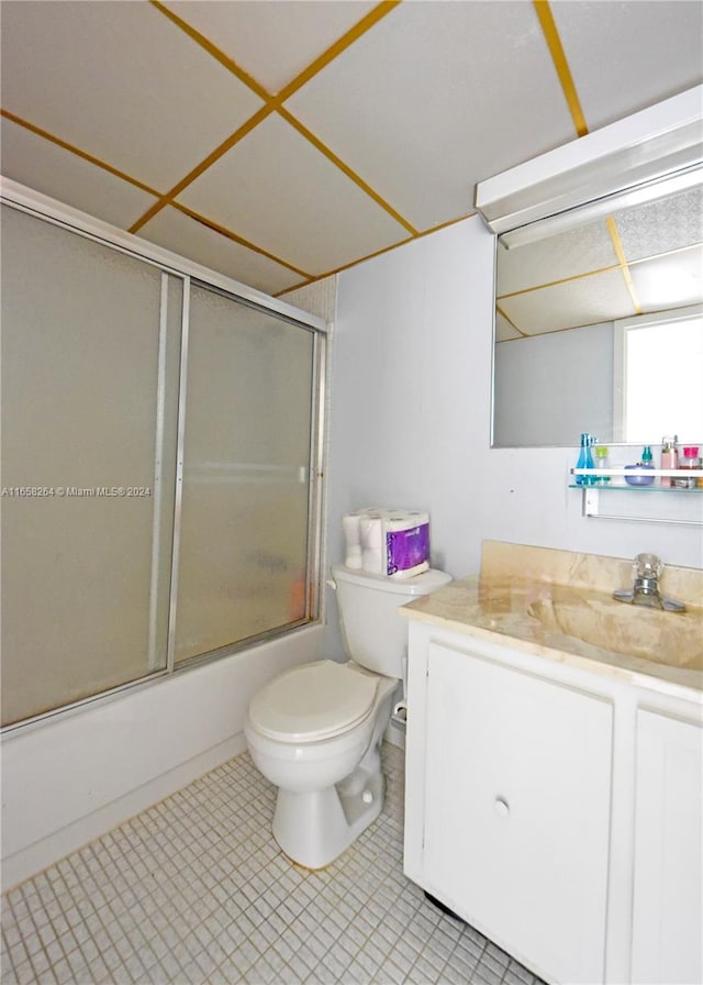 full bathroom with enclosed tub / shower combo, vanity, and toilet