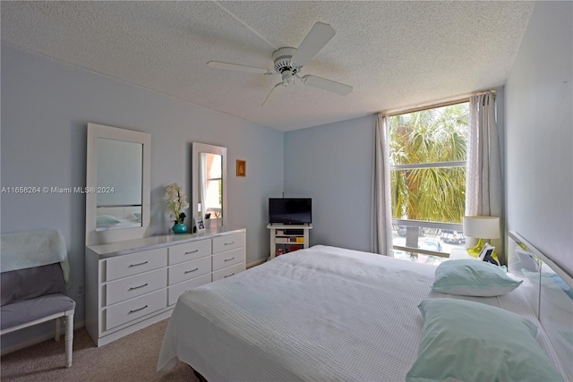 carpeted bedroom featuring a textured ceiling and ceiling fan