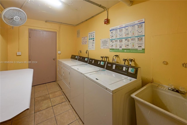 laundry area featuring independent washer and dryer, light tile patterned flooring, and sink