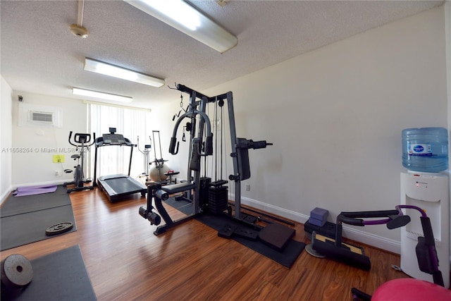 exercise room with hardwood / wood-style flooring and a textured ceiling