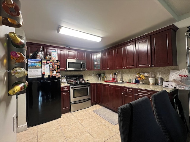 kitchen featuring light tile patterned floors, appliances with stainless steel finishes, sink, and tasteful backsplash