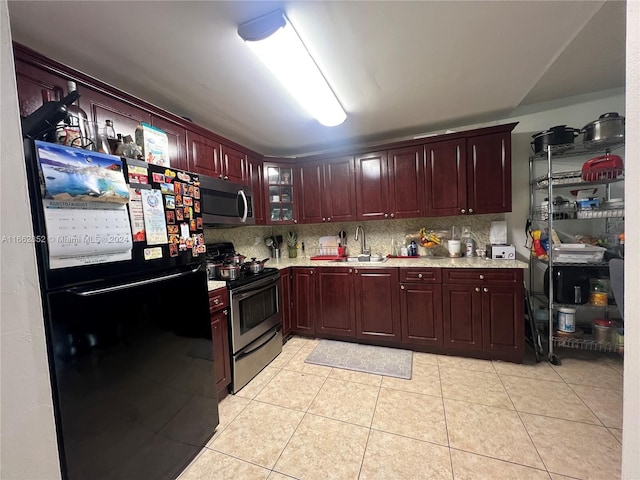 kitchen with backsplash, sink, light tile patterned floors, and stainless steel appliances