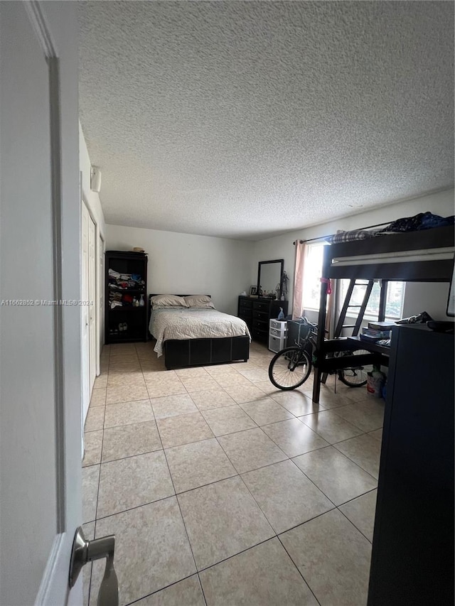 bedroom with a textured ceiling and light tile patterned floors