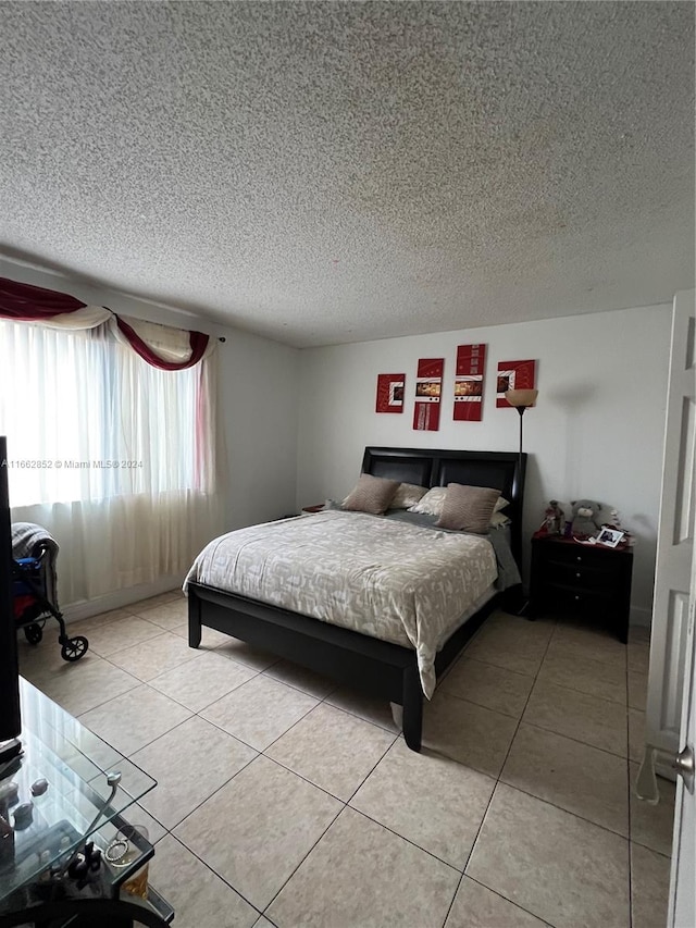 tiled bedroom featuring a textured ceiling