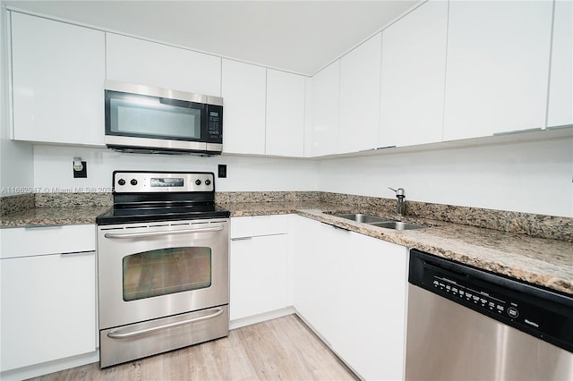 kitchen with stainless steel appliances, sink, and white cabinets