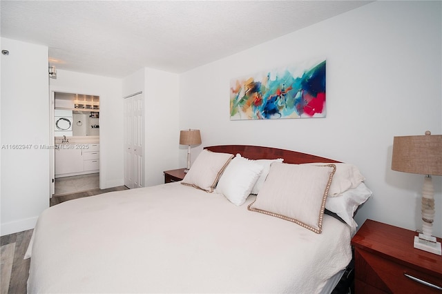 bedroom with connected bathroom, a closet, and a textured ceiling