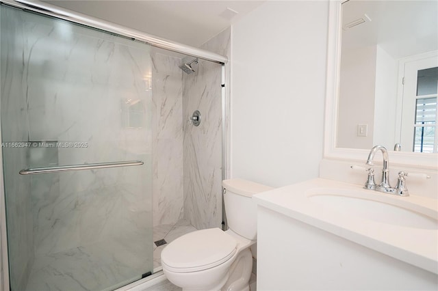 bathroom featuring vanity, toilet, and a shower with shower door