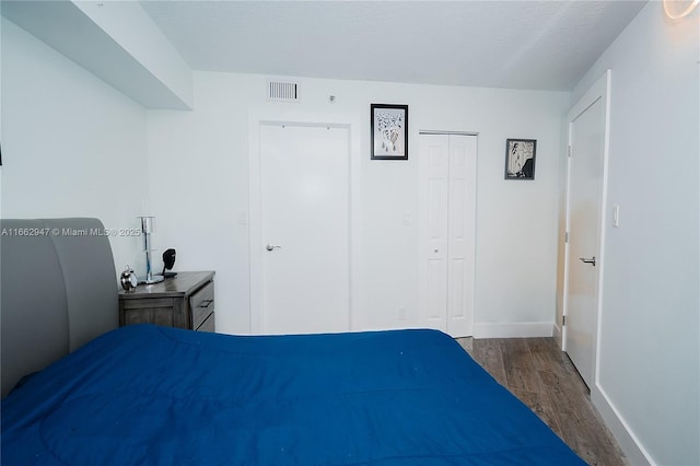 bedroom with hardwood / wood-style flooring, a closet, and a textured ceiling