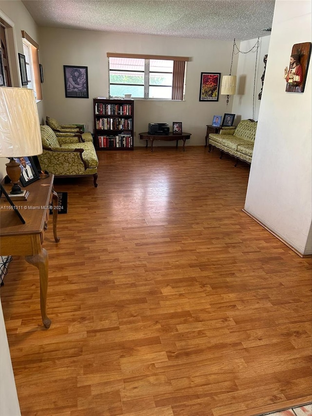 interior space featuring light wood-type flooring and a textured ceiling