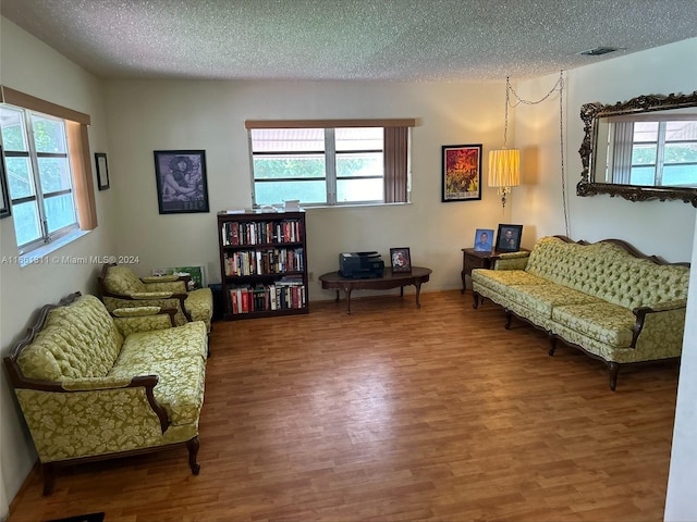 living area featuring hardwood / wood-style flooring and a textured ceiling