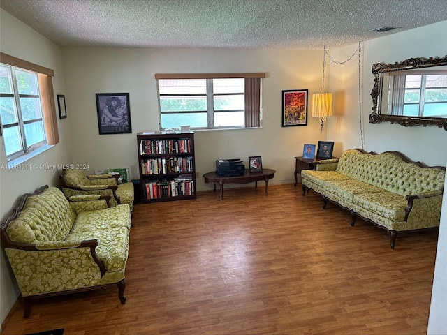 living area with hardwood / wood-style flooring and a textured ceiling