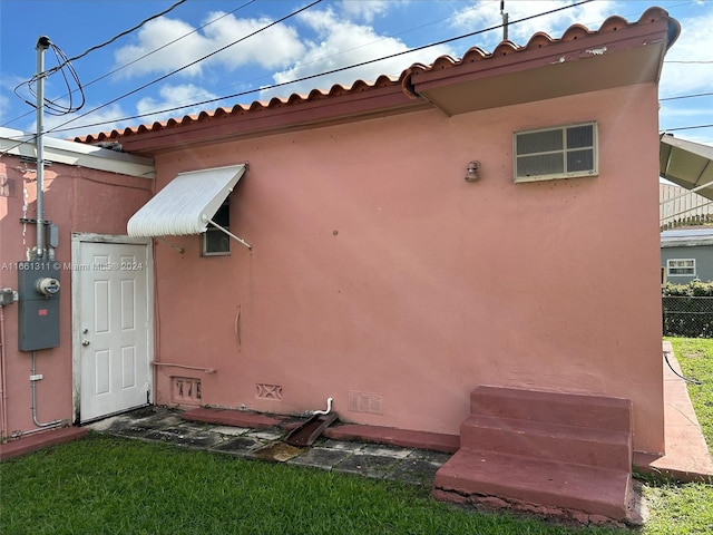 rear view of property featuring a lawn