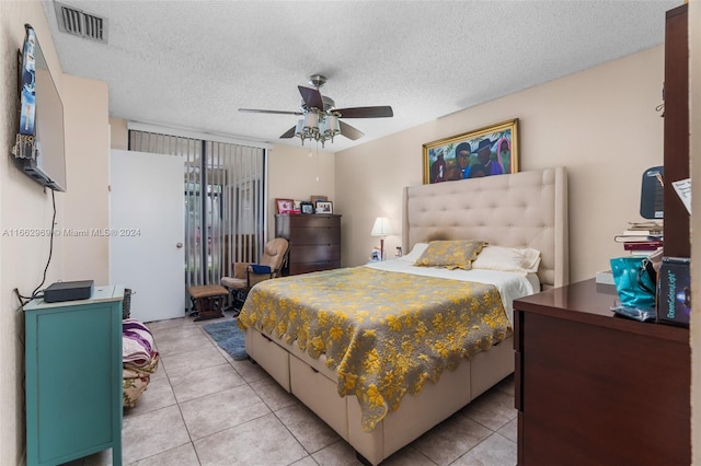 bedroom with ceiling fan, a textured ceiling, and light tile patterned floors