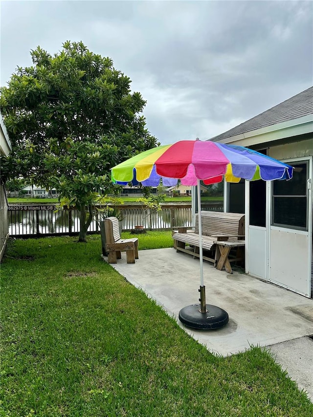 view of yard with a water view and a patio area