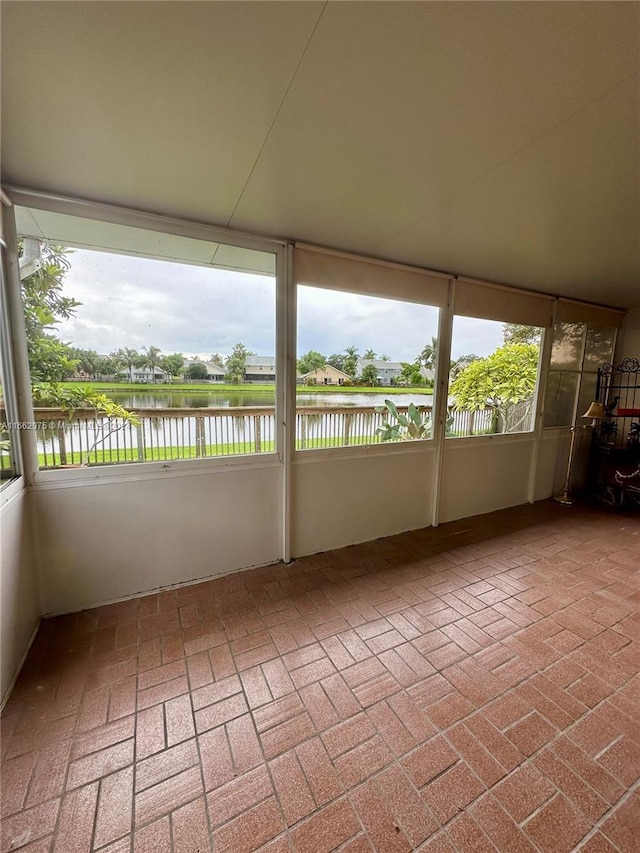 unfurnished sunroom featuring plenty of natural light and a water view