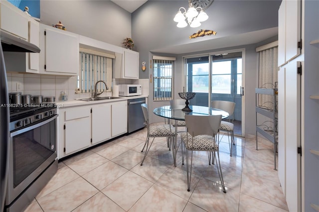 kitchen with white cabinets, light tile patterned flooring, appliances with stainless steel finishes, and sink