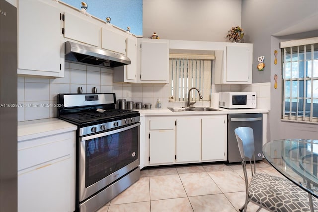 kitchen with white cabinets, light tile patterned flooring, sink, backsplash, and appliances with stainless steel finishes