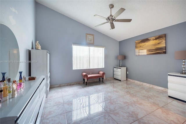 sitting room featuring vaulted ceiling, ceiling fan, light tile patterned flooring, and a textured ceiling