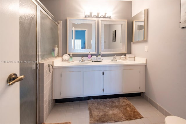 bathroom featuring tile patterned flooring, an enclosed shower, and vanity