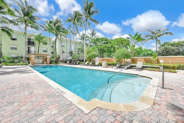 community pool featuring fence and a patio