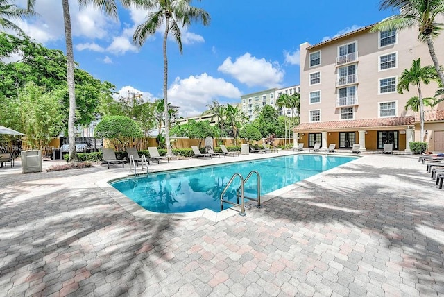community pool featuring fence and a patio