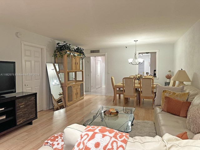 living room with a notable chandelier and light wood-type flooring