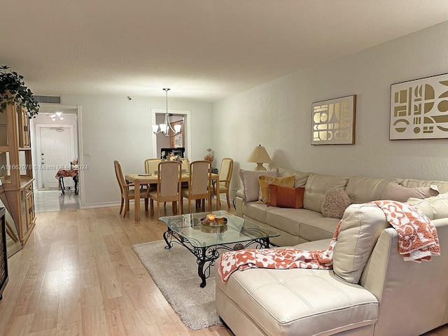 living room featuring a notable chandelier and light hardwood / wood-style floors