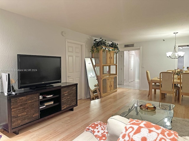 living room with a notable chandelier and light hardwood / wood-style floors