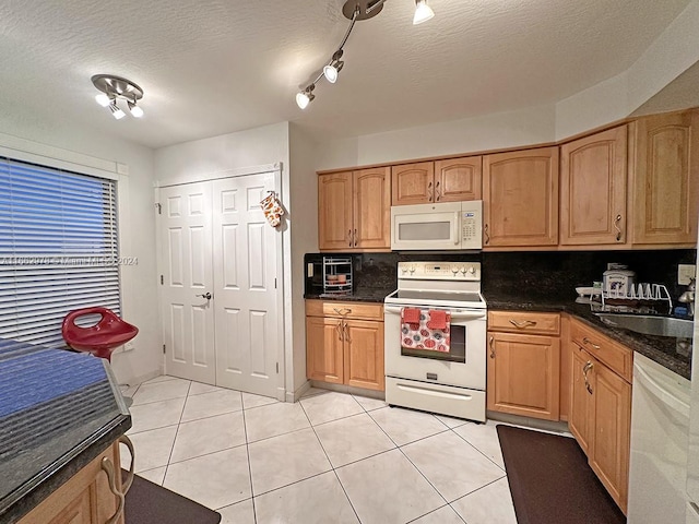 kitchen with decorative backsplash, white appliances, a textured ceiling, and light tile patterned flooring