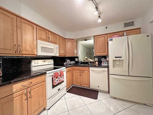 kitchen featuring decorative backsplash, light tile patterned flooring, white appliances, a textured ceiling, and sink