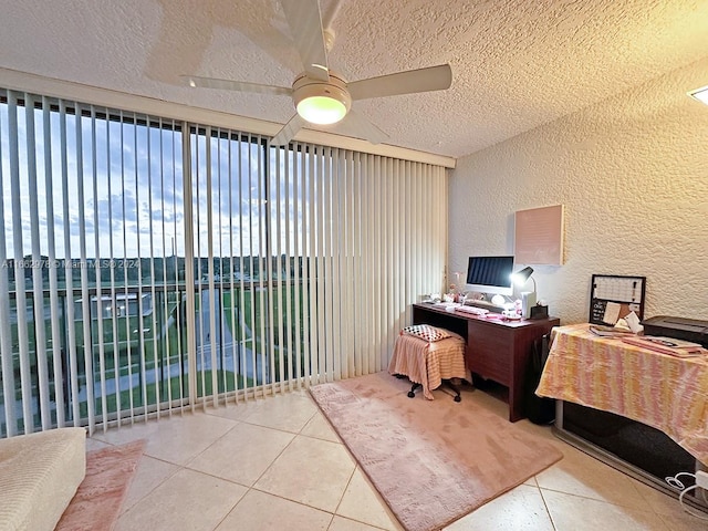 tiled office space with ceiling fan and a textured ceiling