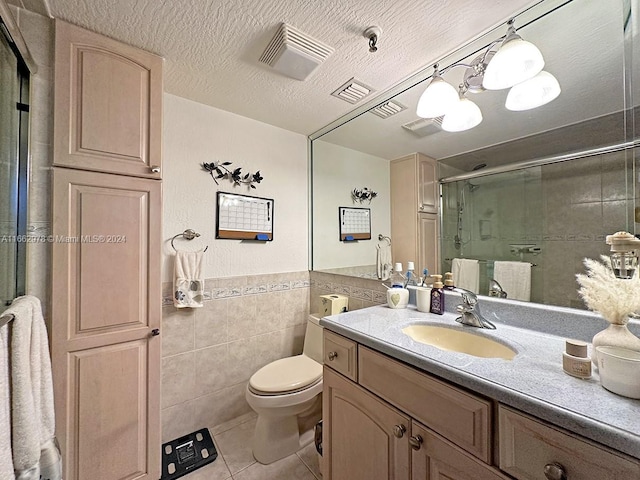 bathroom featuring tile walls, tile patterned flooring, a shower with shower door, vanity, and toilet