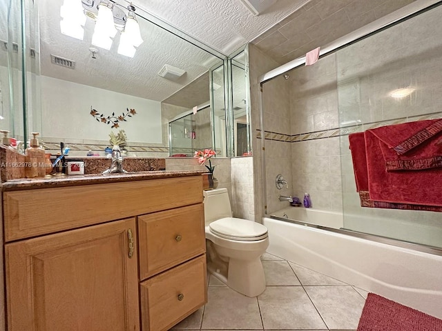 full bathroom featuring vanity, a textured ceiling, tile patterned flooring, combined bath / shower with glass door, and toilet