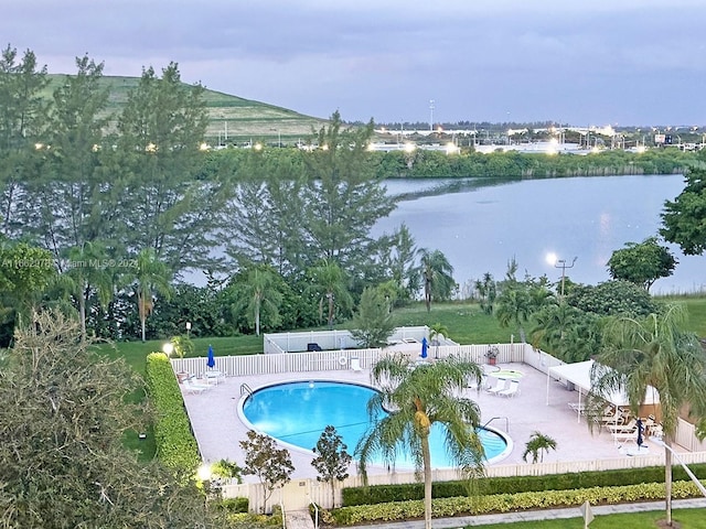 view of pool with a water view and a patio area