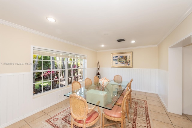 dining space with light tile patterned flooring and crown molding