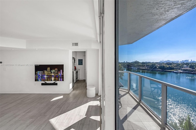 balcony featuring visible vents and a water view