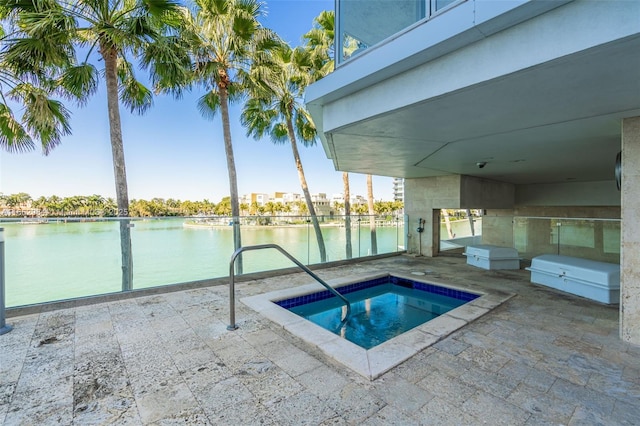 view of swimming pool featuring a community hot tub, a patio area, and a water view