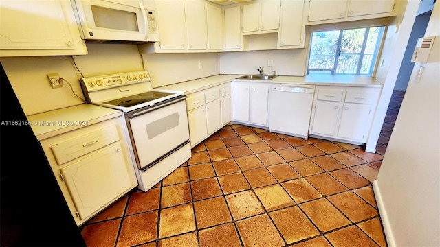 kitchen with white appliances, sink, and white cabinets